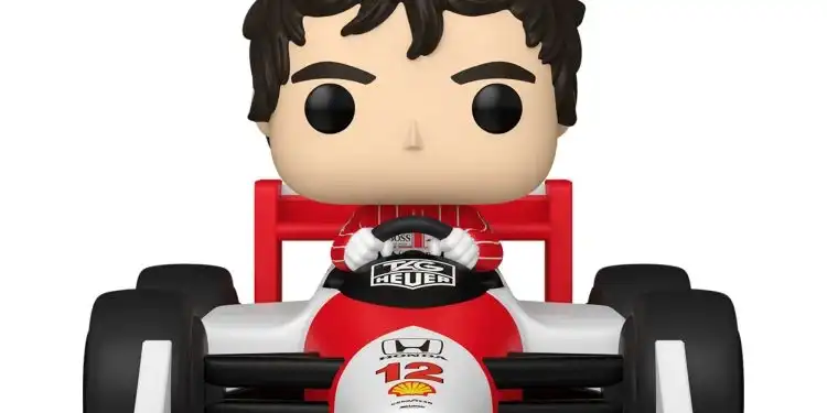 Um boneco Funko Pop de Ayrton Senna sentado em seu carro de Fórmula 1 McLaren Honda branco e vermelho. Ele usa um macacão de corrida vermelho e tem as mãos no volante. O número 12 está visível na frente do carro.