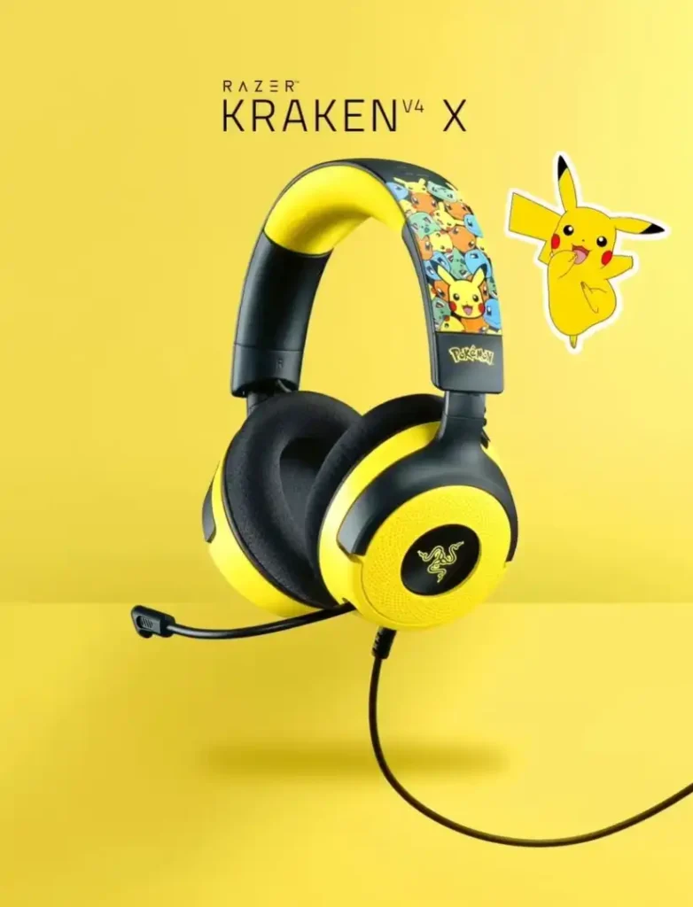 Um conjunto de fones de ouvido Razer Kraken V4 X é apresentado em um fundo amarelo sólido. Os fones de ouvido são predominantemente pretos com detalhes em amarelo nos fones e na parte superior da faixa de cabeça. A parte superior da faixa de cabeça apresenta uma impressão de vários personagens Pokémon, com Pikachu em destaque. Um adesivo digital de Pikachu está posicionado ao lado dos fones de ouvido. O logotipo da Razer está visível na lateral de um dos fones de ouvido, e o nome do produto "KRAKEN V4 X" aparece em texto preto na parte superior da imagem. Um microfone preto estende-se de um dos fones de ouvido, e um cabo preto sai do outro fone.