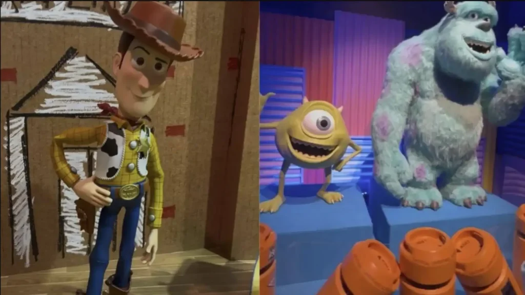 Uma imagem dividida verticalmente mostra dois painéis. O painel esquerdo apresenta um boneco do Woody, de "Toy Story", em pé contra um fundo de papelão com um desenho de uma casa simples. O boneco está sorrindo levemente e tem a mão direita na cintura. O painel direito exibe as figuras de Mike Wazowski e Sulley, de "Monstros S.A.", em um cenário com tons roxos e azuis, e alguns objetos cilíndricos alaranjados na parte inferior. Ambos os monstros estão sorrindo, e Sulley está acenando com uma de suas patas.