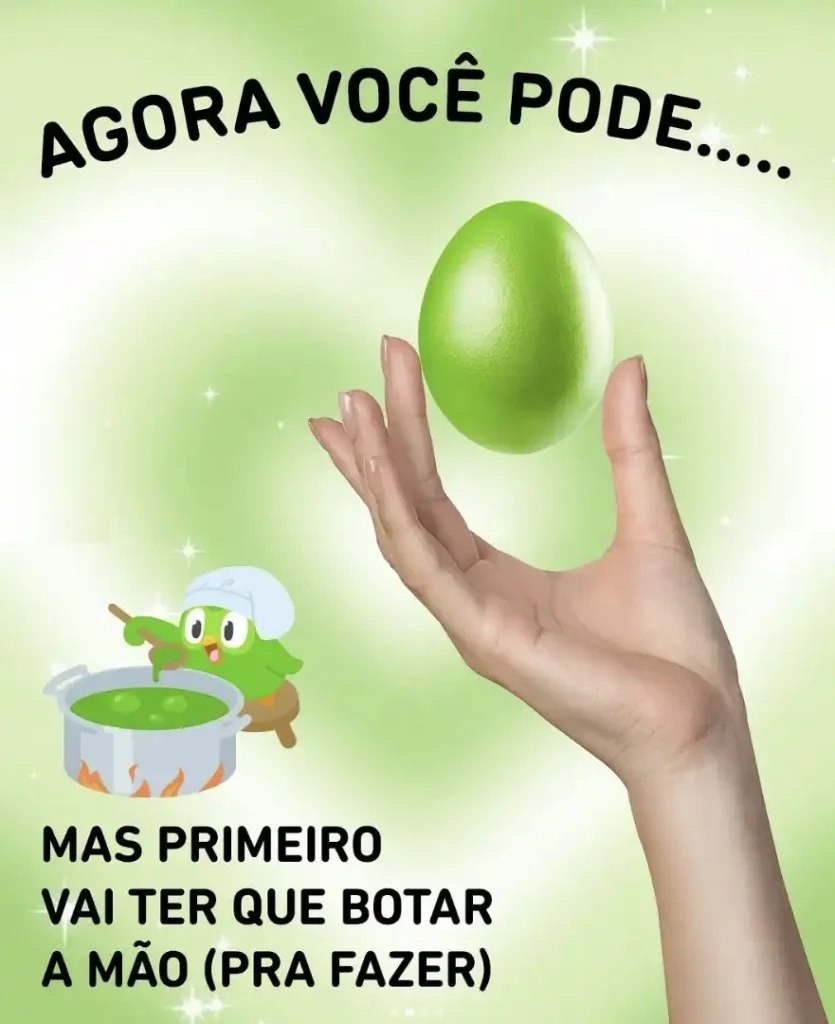 Uma imagem promocional vibrante e divertida do Duolingo. O fundo é um gradiente suave de verde e branco com brilhos cintilantes. No canto superior esquerdo, em letras pretas maiúsculas, está escrito "AGORA VOCÊ PODE....".
No centro da imagem, uma mão de pele clara segura um ovo grande e verde-limão, que lembra o ícone do Duolingo. A mão está ligeiramente inclinada para a direita, e o ovo parece flutuar acima dela, com um leve brilho.
No canto inferior esquerdo, está o mascote de coruja verde do Duolingo, Duo, usando um chapéu de chef branco e mexendo um caldeirão verde com uma colher de pau. O caldeirão está sobre chamas estilizadas.
Abaixo da mão e do caldeirão, em letras pretas maiúsculas, lê-se: "MAS PRIMEIRO VAI TER QUE BOTAR A MÃO (PRA FAZER)". A imagem sugere que, para alcançar o que se deseja (simbolizado pelo ovo), é preciso primeiro se esforçar e "colocar a mão na massa".