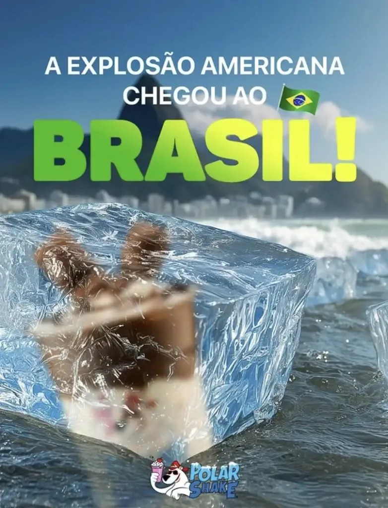 Uma imagem vibrante mostra um grande bloco de gelo transparente flutuando na água, revelando um sorvete ou doce congelado parcialmente visível em seu interior. A cena é ambientada em uma praia ensolarada, com o oceano e montanhas ao fundo, incluindo o que parece ser o Pão de Açúcar ou montanhas semelhantes no Rio de Janeiro. No topo da imagem, há um texto em português que diz "A EXPLOSÃO AMERICANA CHEGOU AO BRASIL!" em letras brancas, com a palavra "BRASIL!" em destaque em letras verdes e um emoji da bandeira do Brasil ao lado. No canto inferior direito, há o logotipo de uma marca chamada "Polar Shake", que apresenta um urso polar.
