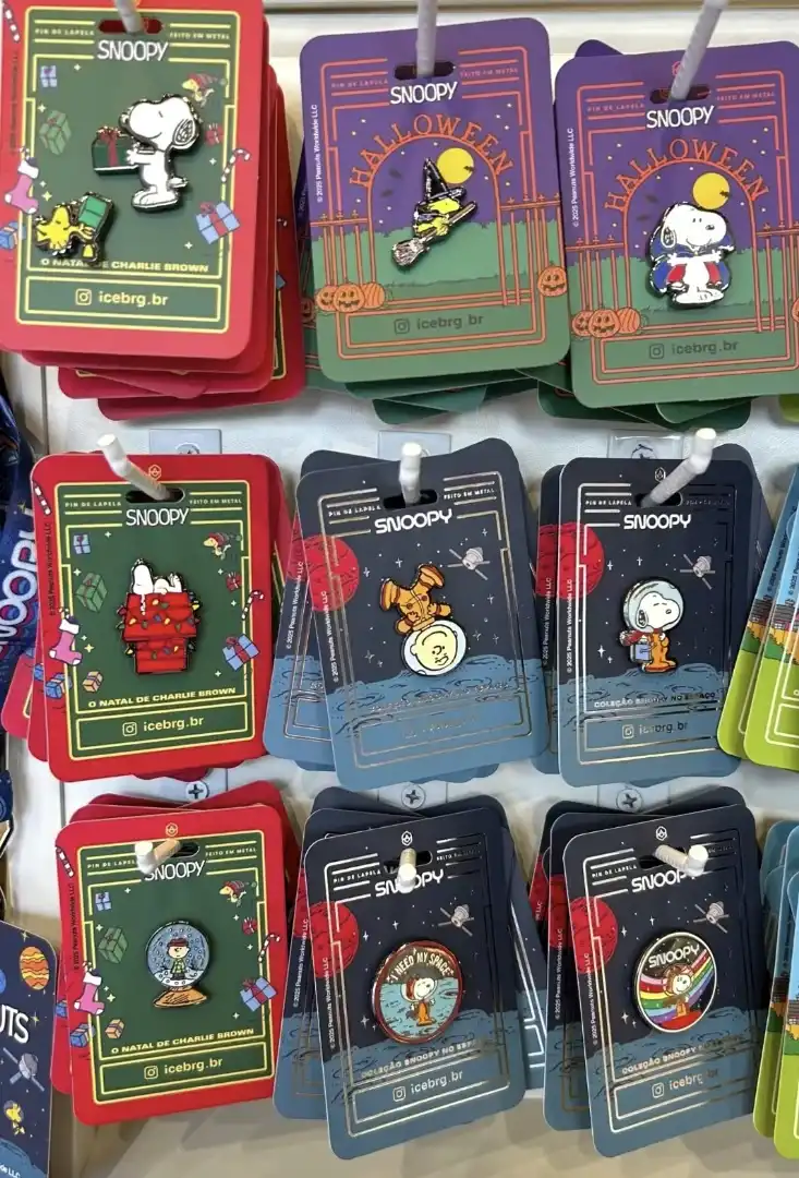 Coleção de pins de Snoopy com temas de Natal, Halloween e espaço.