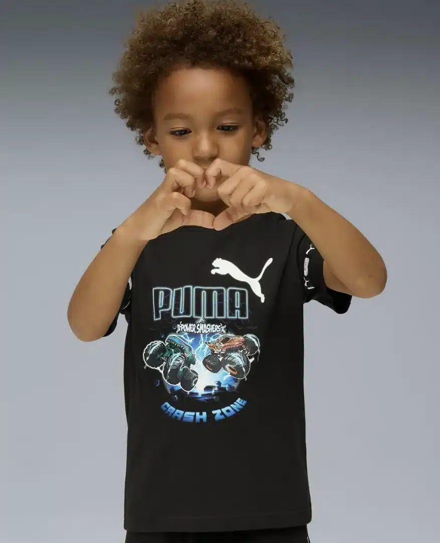 Criança fazendo um coração com as mãos, usando camiseta preta da Puma e Hot Wheels.