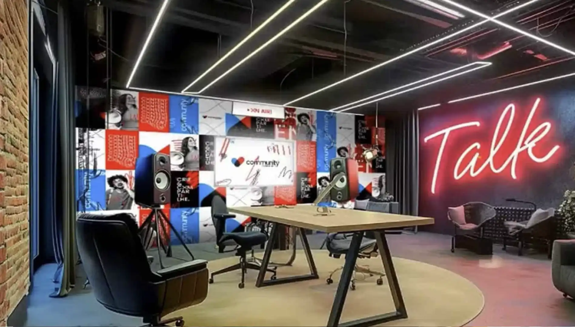 Um estúdio de podcast ou sala de reunião com uma grande mesa de madeira, uma tela com o logo "community" e um letreiro de neon vermelho escrito "Talk".
