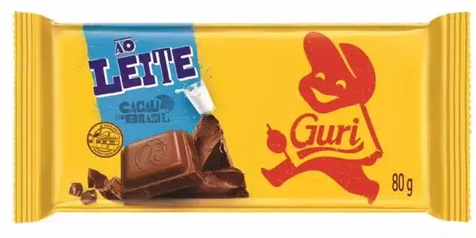 Barra de chocolate ao leite Guri, com embalagem amarela e vermelha, e um desenho animado de um menino com um boné.