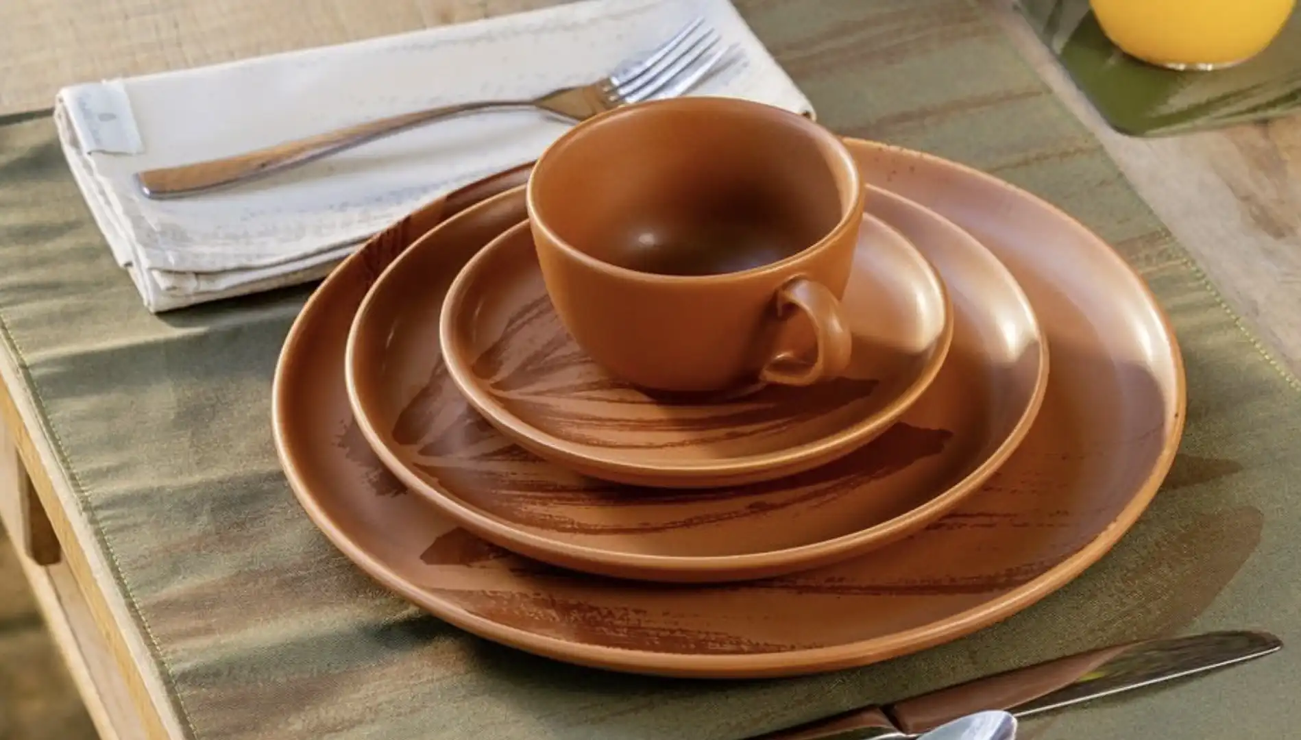 Uma pilha de louças de cerâmica marrom em uma mesa.
