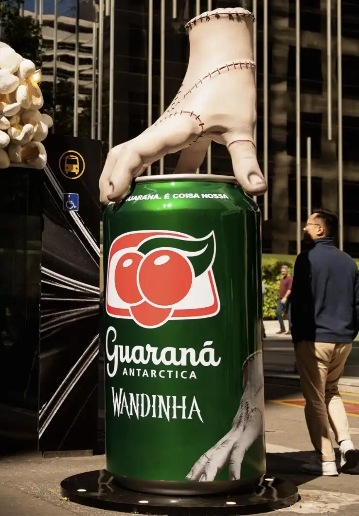 Uma grande escultura da Mãozinha da Família Addams repousando sobre uma lata gigante de Guaraná Antarctica Wandinha.