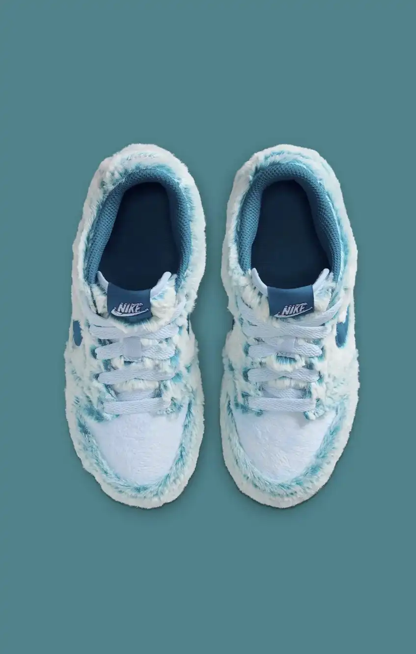 Par de tênis Nike Dunk Low "Abominável Homem das Neves" em vista de cima, destacando a textura de pelo azul e branco e os cadarços.