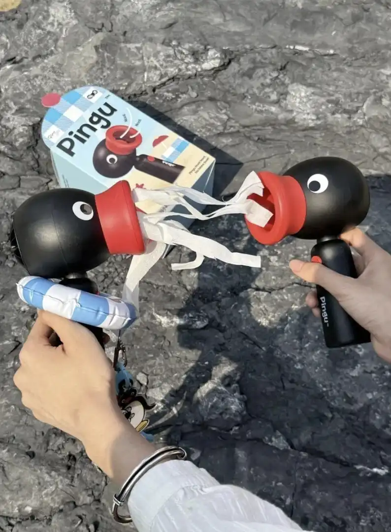 Criança segurando ventilador portátil do Pingu