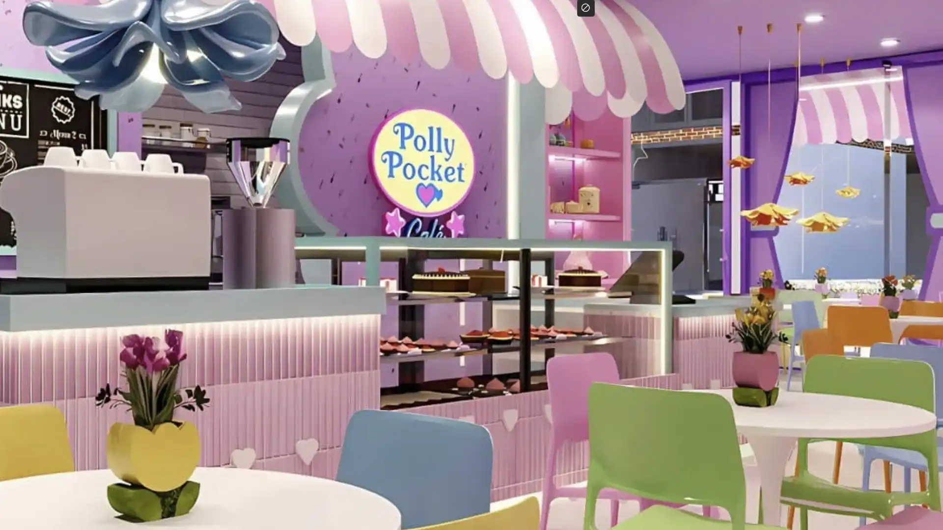 Interior de um café temático da Polly Pocket, com balcão de doces e mesas coloridas.
