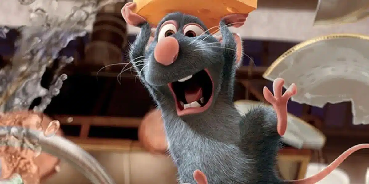 O rato Remy, do filme "Ratatouille", está segurando um grande pedaço de queijo sobre a cabeça com uma expressão de êxtase e boca aberta.