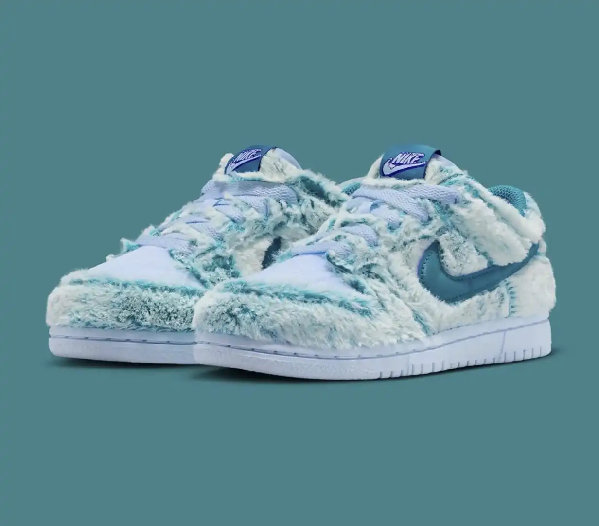 Par de tênis Nike Dunk Low "Abominável Homem das Neves" com textura de pelo nas cores azul e branco, vistos de frente.