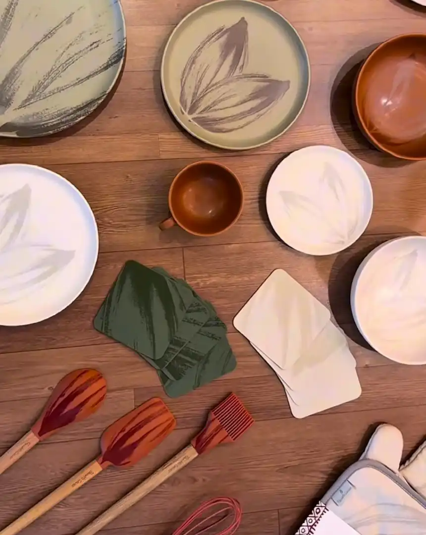 Vários utensílios de cozinha e louças da linha Bendito Cacao em uma superfície de madeira.