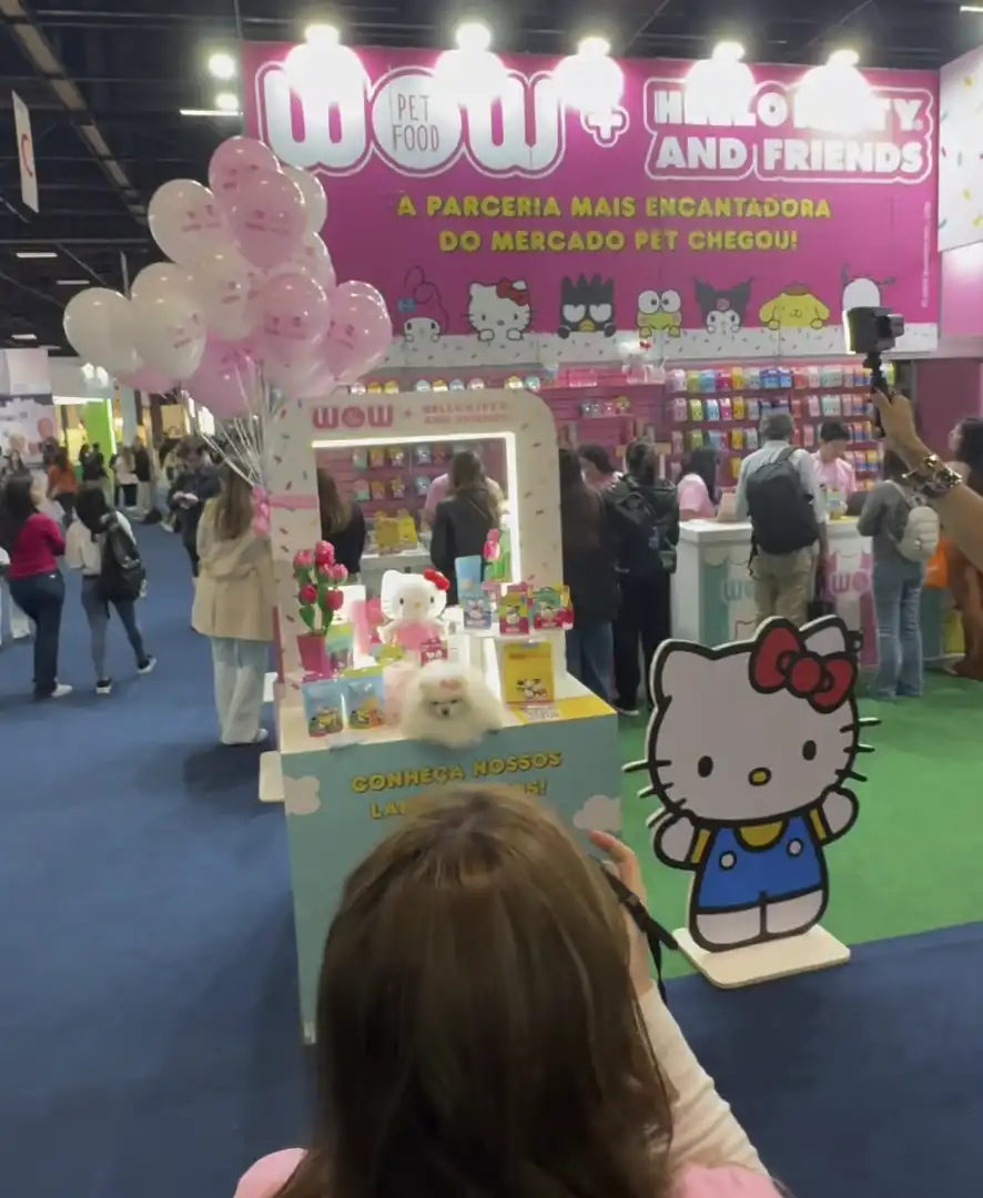 Estande da marca de pet food com o tema da Hello Kitty em uma feira, com balões e uma silhueta do personagem Hello Kitty.