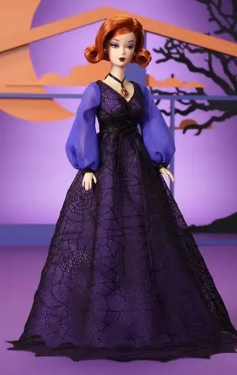 Uma boneca Barbie em um vestido de bruxa roxo e preto.