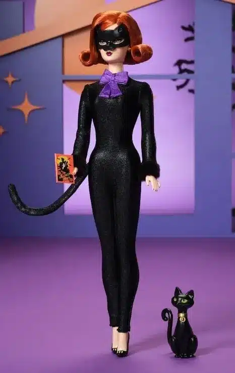 Uma boneca Barbie vestida de Mulher-Gato com um macacão preto e uma máscara.