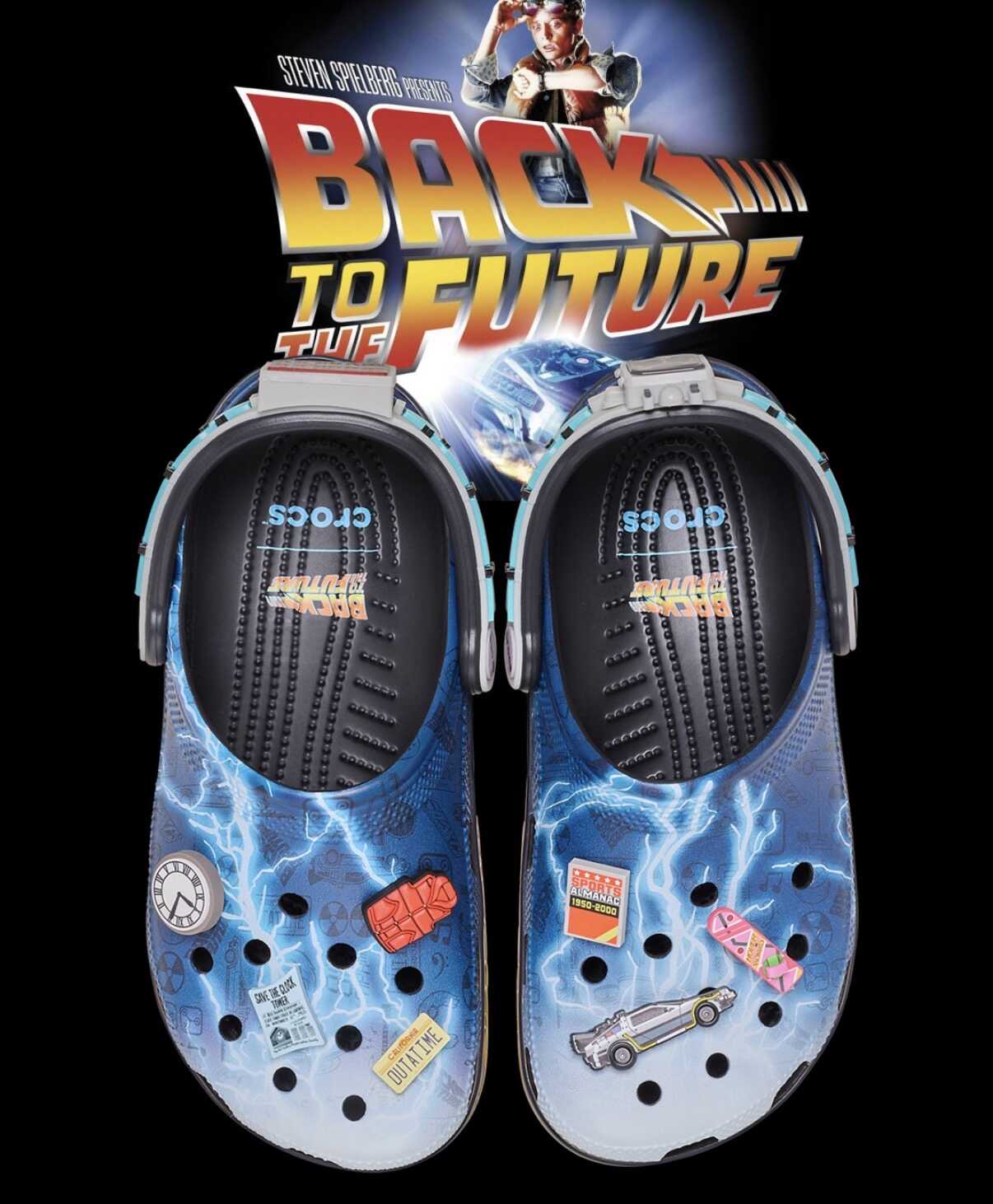 Par de tamancos Crocs Classic Clog "De Volta para o Futuro" com estampa de raios e pinos Jibbitz temáticos, como o DeLorean, o Almanaque Esportivo, um relógio e um skate.