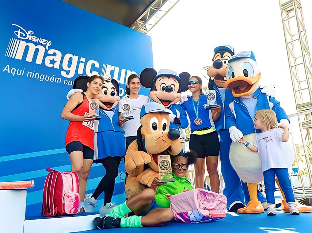 Personagens Disney e participantes em pódio do evento "Disney Magic Run".