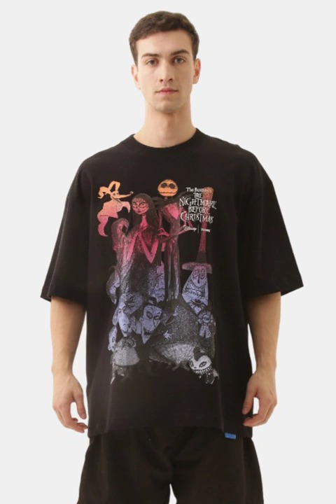 Um homem vestindo uma camiseta preta com uma estampa colorida e em estilo pôster dos personagens de "O Estranho Mundo de Jack".