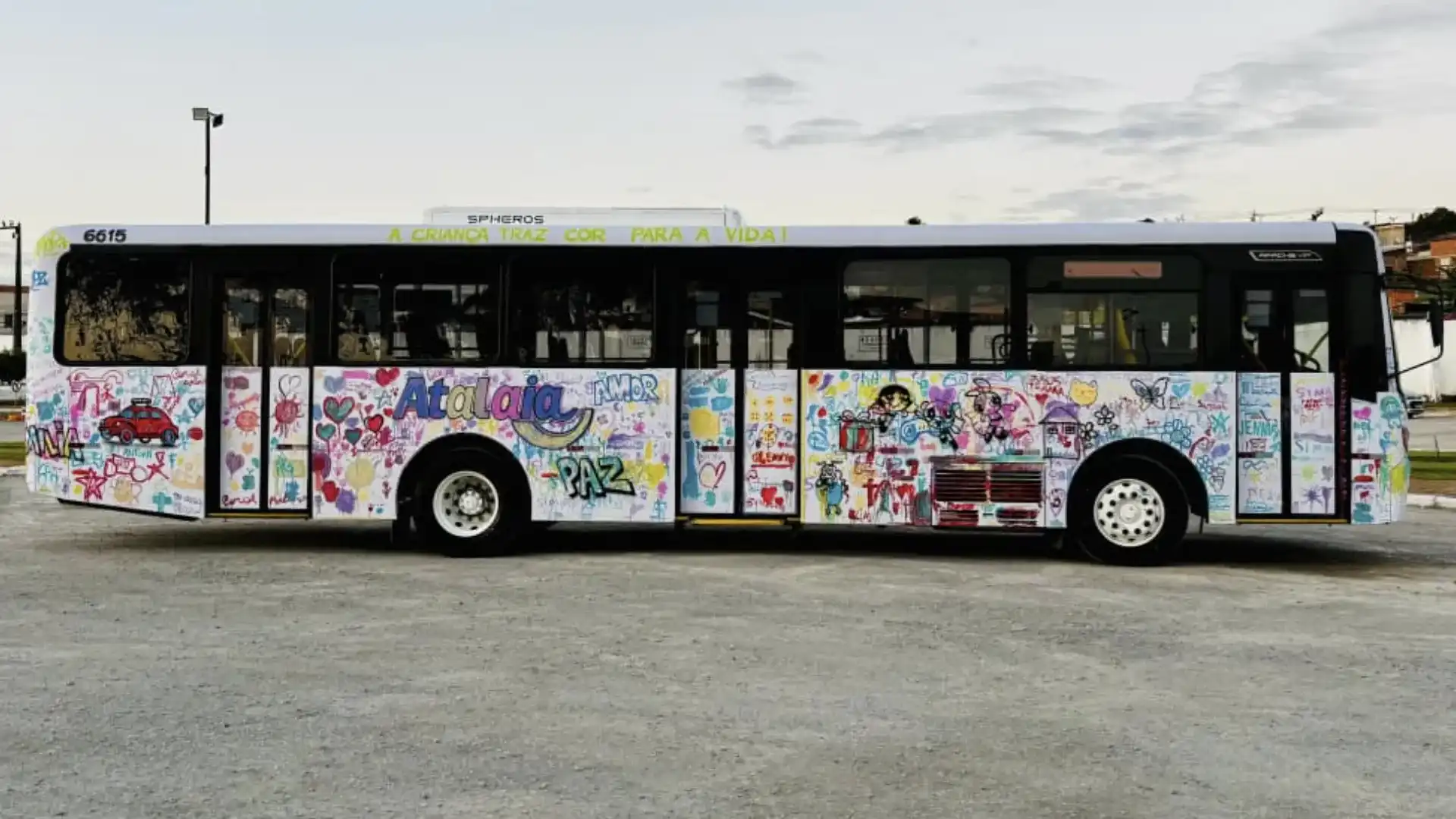 Ônibus branco coberto de desenhos coloridos feitos por crianças.