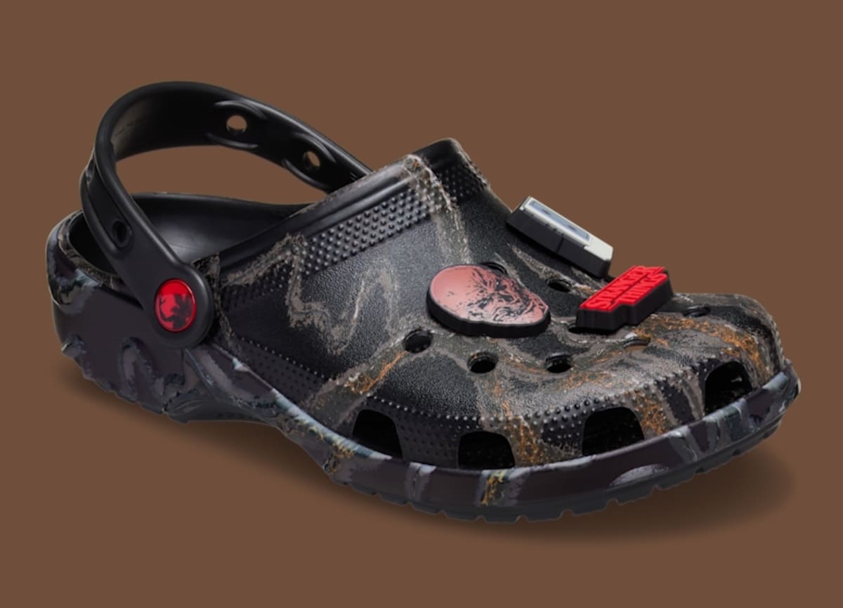 Um Croc preto com estampa marmorizada de Stranger Things, com Jibbitz temáticos.