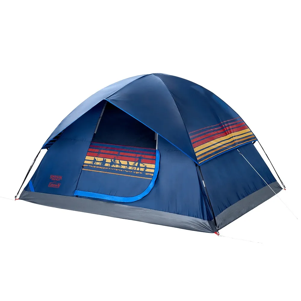 Tenda de camping Coleman azul escuro com detalhes em listras horizontais vermelhas, amarelas e azuis, e silhuetas de personagens no estilo de Stranger Things, com porta aberta revelando interior escuro.