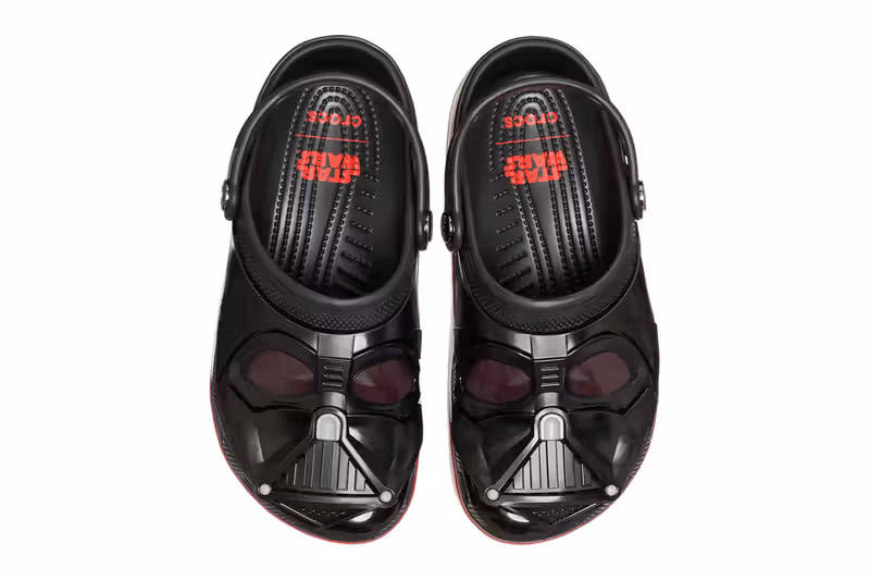 Par de Crocs pretos em colaboração com Star Wars, visto de cima, com a ponta moldada como o capacete de Darth Vader.