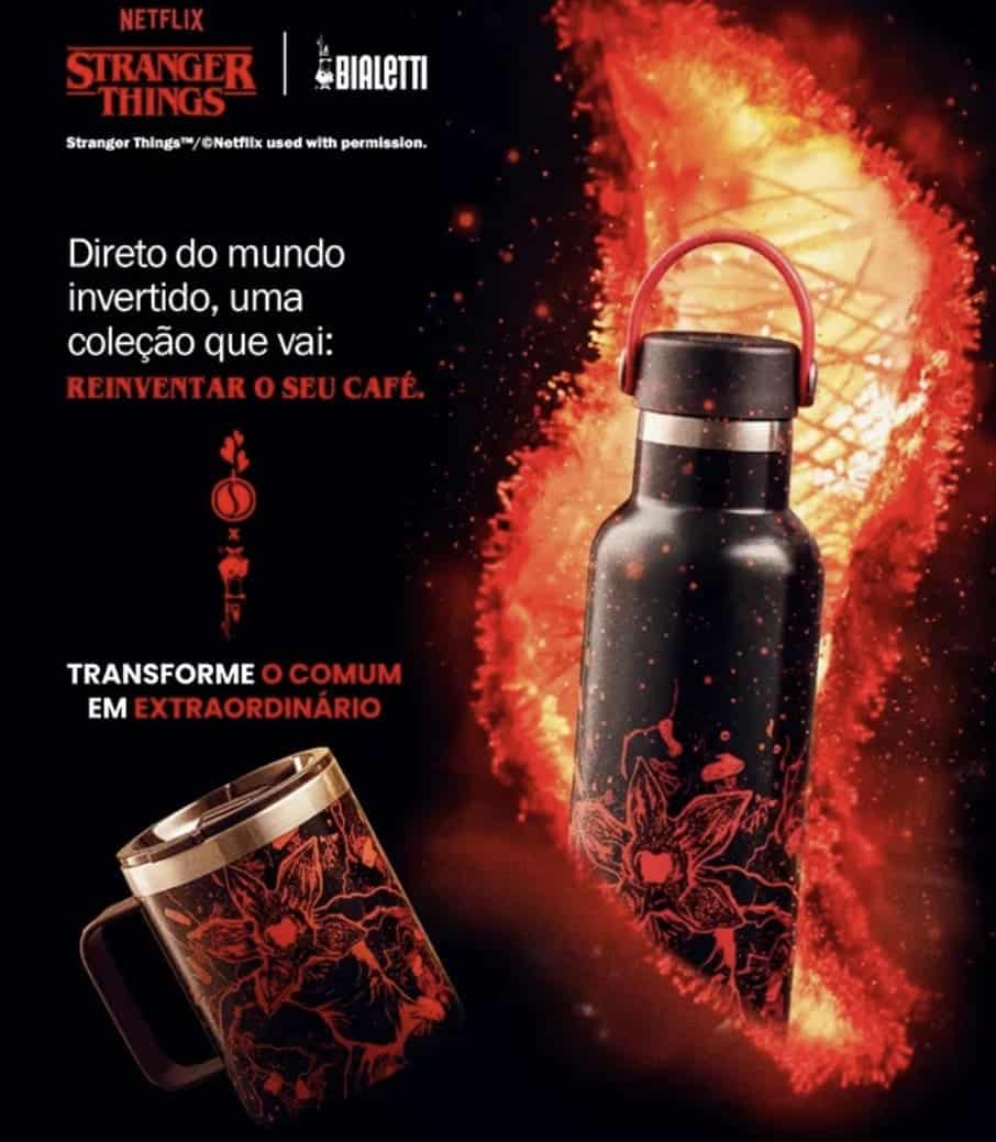 Anúncio da colaboração Netflix Stranger Things e Bialetti. A imagem em tons de preto e laranja ardente mostra uma garrafa térmica e uma caneca isolada, ambas estampadas com um design floral demoníaco inspirado no Mundo Invertido, com o texto: "Direto do mundo invertido, uma coleção que vai: REINVENTAR O SEU CAFÉ. TRANSFORME O COMUM EM EXTRAORDINÁRIO."