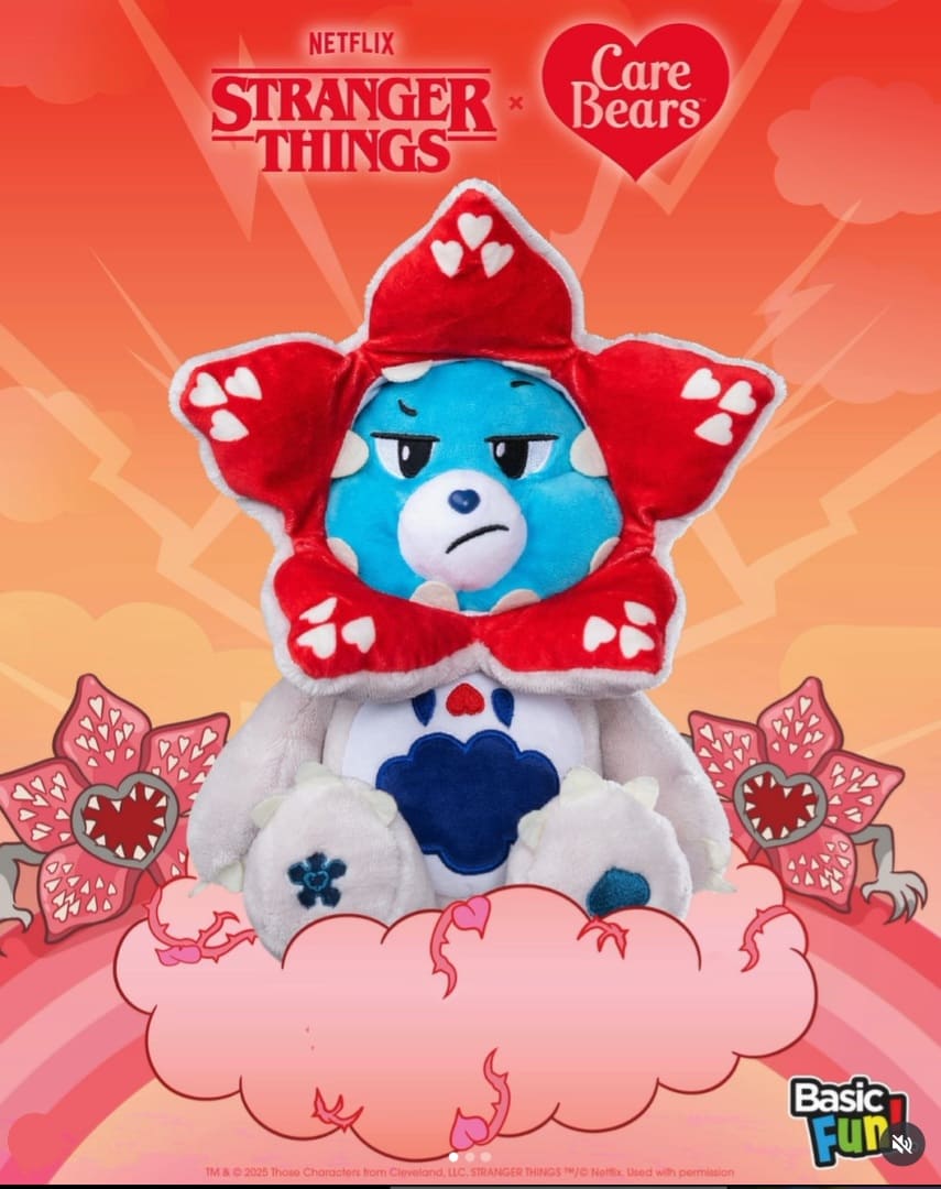 Ursinho Carinhoso (Care Bear) azul-claro com expressão de raiva, usando um capuz vermelho e branco estilizado como a cabeça aberta de um Demogorgon, com o símbolo de um flocos de neve azul-escuro na barriga, sentado em uma nuvem rosa.