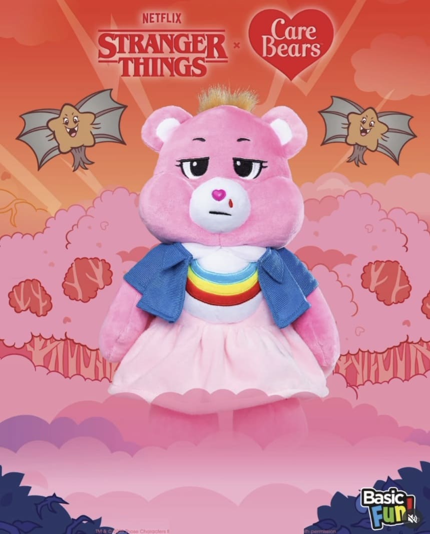 Ursinho Carinhoso (Care Bear) rosa com uma gota de sangue escorrendo do nariz, vestindo um vestido rosa e uma jaqueta jeans azul, com o símbolo do arco-íris na barriga, posicionado à frente de grandes nuvens rosa.
