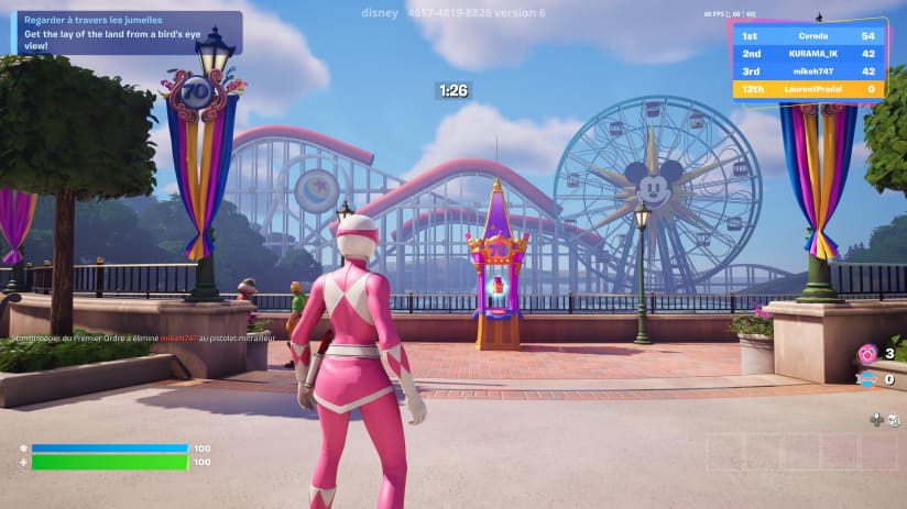 Captura de tela do jogo Fortnite: personagem Power Ranger Rosa em um mapa temático da Disneyland, com uma montanha-russa e a roda-gigante do Mickey Mouse ao fundo, exibindo a marca '70'.