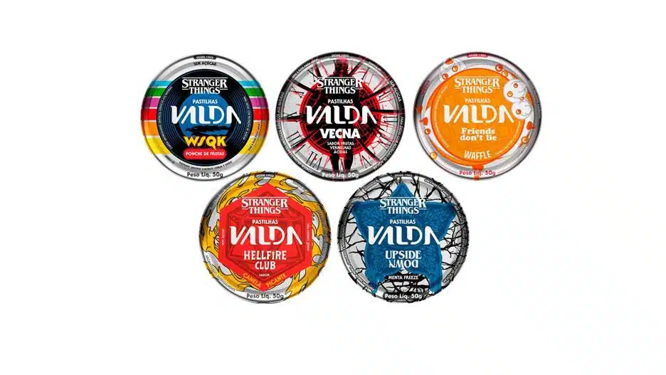 Cinco latas redondas de pastilhas Valda da coleção Stranger Things: W$QK (Ponche de Frutas), Vecna (Rosas Silvestres, Pimenta e Especiarias), Friends Don't Lie (Waffle), Hellfire Club (Pimenta e Canela) e Upside Down (Menta Freeze).