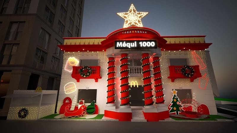 Fachada de uma loja McDonald's decorada para o Natal com luzes e elementos vermelhos, incluindo a frase "Méqui 1000" e uma grande estrela brilhante no topo.